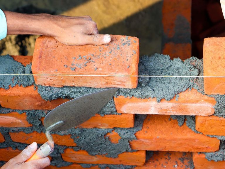 Mauerwerk wird mit Kelle und Richtschnur aufgemauert